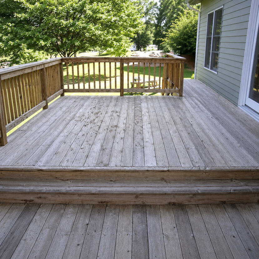 Before and after comparison of a weathered deck restored with a warmer stained finish.